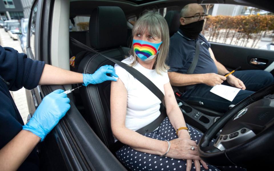 A member of the public receives a flu vaccine while sitting in her car at a drive-through flu clinic in Edinburgh - Jane Barlow/PA