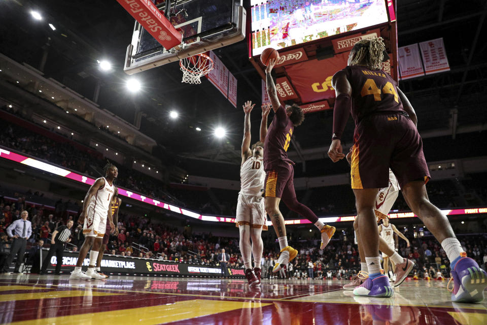 Arizona State guard Jose Perez (12) shoots against Southern California forward DJ Rodman (10) during the second half of an NCAA college basketball game Thursday, March 7, 2024, in Los Angeles. Southern California won 81-73. (AP Photo/Raul Romero Jr.)