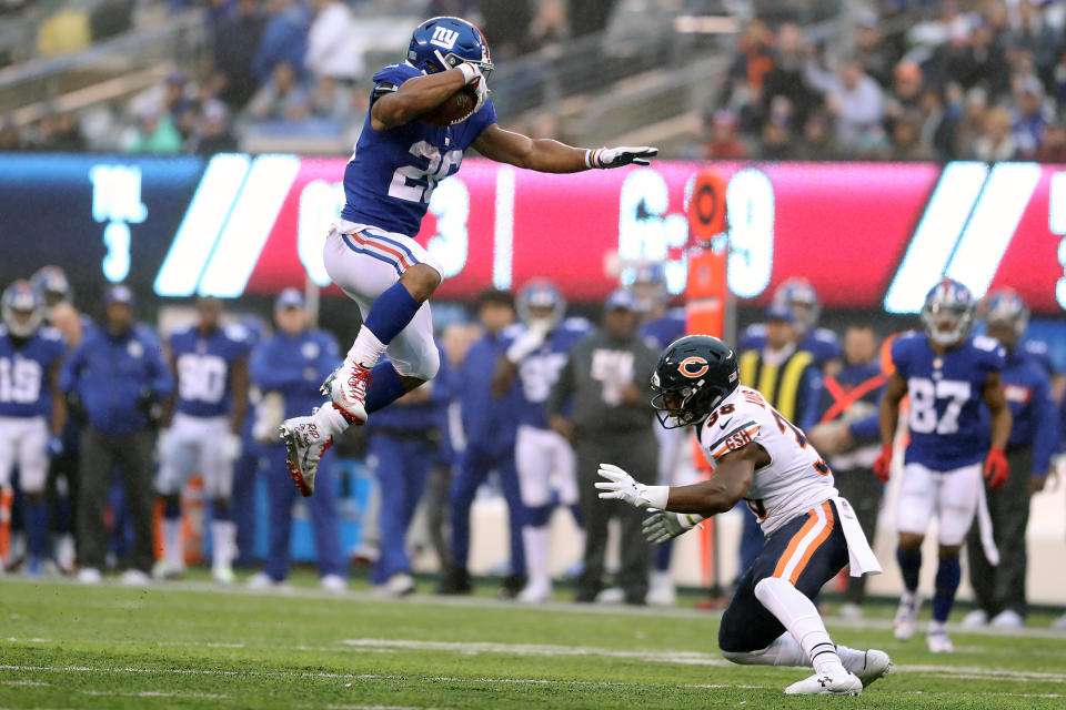 <p>EAST RUTHERFORD, NEW JERSEY – DECEMBER 02: Saquon Barkley #26 of the New York Giants leaps over Adrian Amos #38 of the Chicago Bears for extra yardage during the third quarter at MetLife Stadium on December 02, 2018 in East Rutherford, New Jersey. (Photo by Elsa/Getty Images) </p>