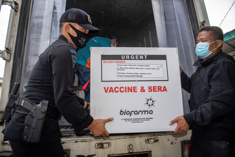 Officers offload a box of Sinovac's vaccine for coronavirus disease (COVID-19) as it arrives at the cold room of Indonesia's local health department in Palembang