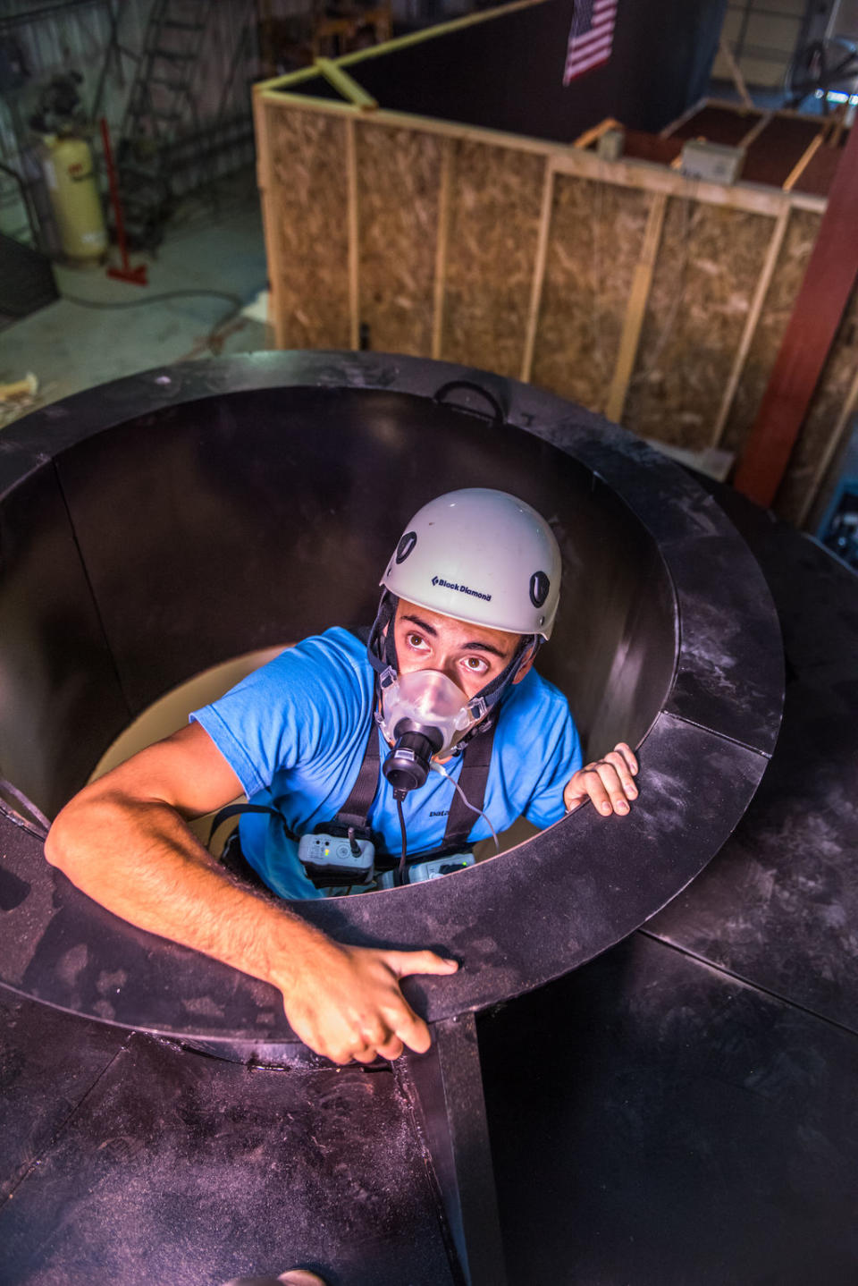 Garret Lovoy, studying nutrition and kinesiology during his senior year at Kansas State University, climbs out of a replica Orion space capsule used to test potential astronauts' health during an emergency escape. <cite>Kansas State University</cite>