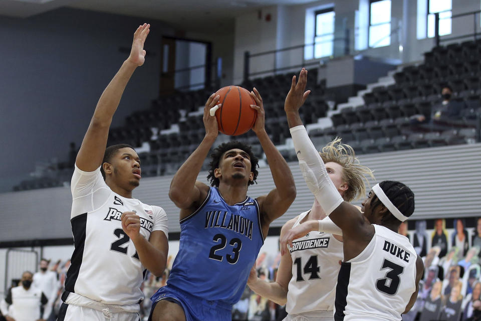 Villanova's Jermaine Samuels (23) drives to the basket against Providence's Ed Croswell (21), Noah Horchler (14) and David Duke (3) during an NCAA college basketball game in Providence, R.I., Saturday, March 6, 2021. (AP Photo/Stew Milne)