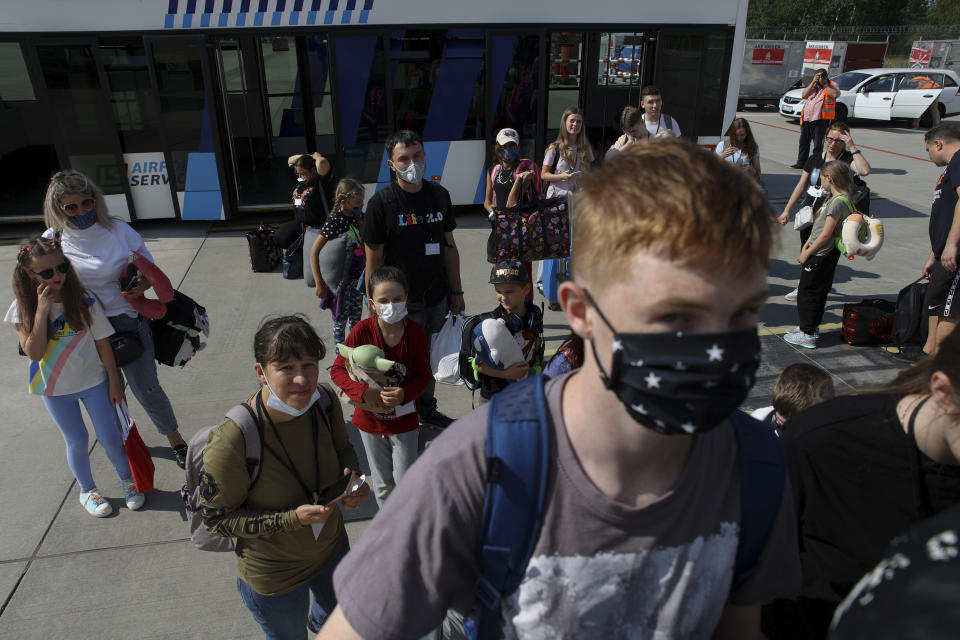 Ukrainian refugees board a plane before flying to Canada, from Frederic Chopin Airport in Warsaw, Poland, Monday, July 4, 2022. Phan Thị Kim Phuc, the girl in the famous 1972 Vietnam napalm attack photo, on Monday escorted 236 refugees from the war in Ukraine on a flight from Warsaw to Canada. Phuc’s iconic Associated Press photo in which she runs with her napalm-scalded body exposed, was etched on the private NGO plane that is flying the refugees to the city of Regina. (AP Photo/Michal Dyjuk)