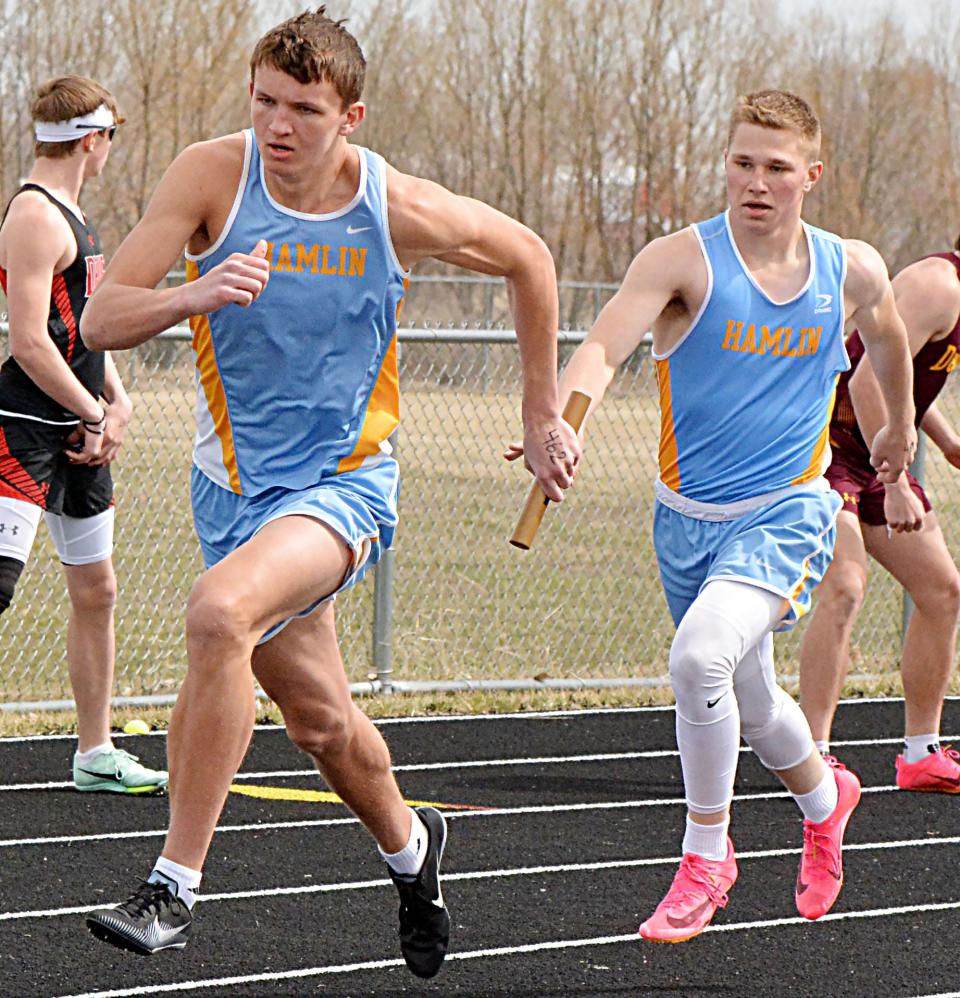 Hamlin's Rylan Thue passes the baton to Zac VanMeeteren in the boys' 800-meter relay during the Pat Gilligan Alumni track and field meet on Tuesday, April 25, 2023 in Estelline.