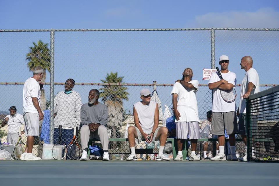 San Quentin State Prison inmates wait for their turn to play tennis against visiting players in San Quentin, Calif., Saturday, Aug. 13, 2022. (AP Photo/Godofredo A. Vásquez)
