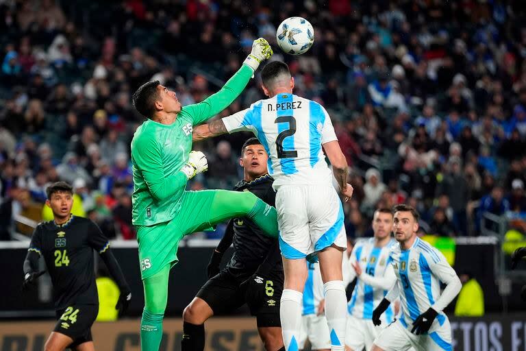 El arquero Mario González despeja con un puño ante el salto de Nehuén Pérez en el primer tiempo entre Argentina y El Salvador.