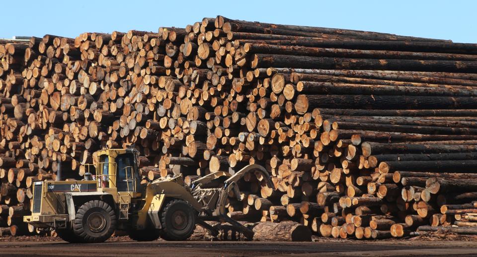 A loader moves logs around the yard at the Seneca Sawmill Co. in Eugene. The Seneca family of companies, which includes the Eugene sawmill, recently was bought by a California-based forest products company.