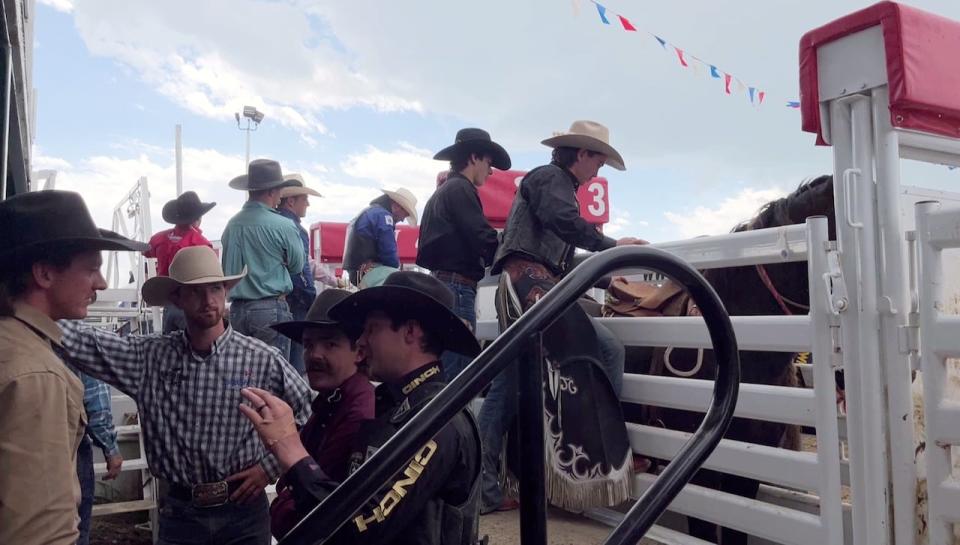 Saddle bronc riders talk in the contestants area behind the bucking chutes at the Sundre Pro Rodeo, June 23.