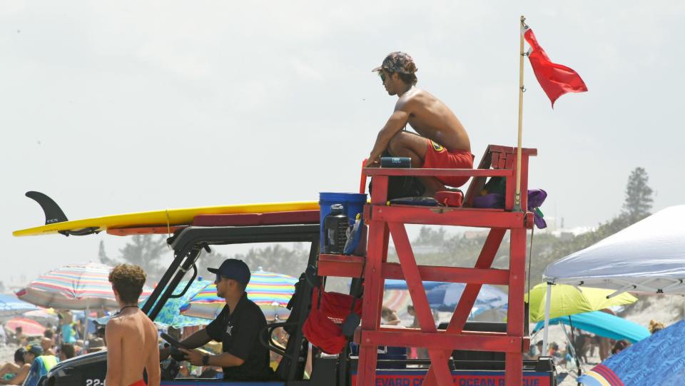 Lifeguards closely watching the beachgoers in the water. The beach at Indialantic near the 5th Avenue Boardwalk on a Sunday afternoon. There have been several drownings in this area in recent weeks.