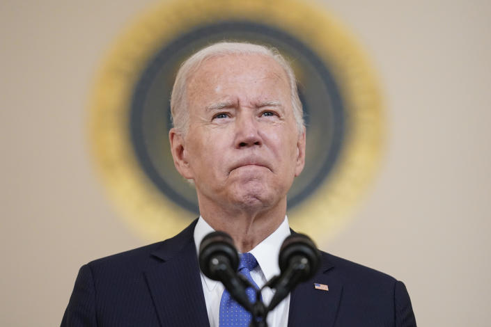 President Biden at the microphone, wearing a pained expression.