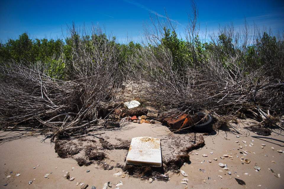 Image: A grave stone rests on the beach where a cemetery once stood but has been washed away due to erosion in an area called Canaan in Tangier, Va., on May 16, 2017. (Jim Watson / AFP via Getty Images file)