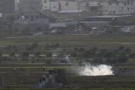 Palestinian protesters run from tear gas fired by Israeli soldiers during clashes, as seen from the Israeli side of the border fence with central Gaza, November 27, 2015. REUTERS/Amir Cohen