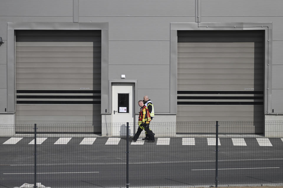 Bomberos caminan frente a una fábrica de autos Tesla paralizada por un apagón que obligó a evacuar a los trabajadores, en Grünheide, Añlemania, martes 5 de marzo de 2024. (Sebastian Gollnow/dpa via AP)