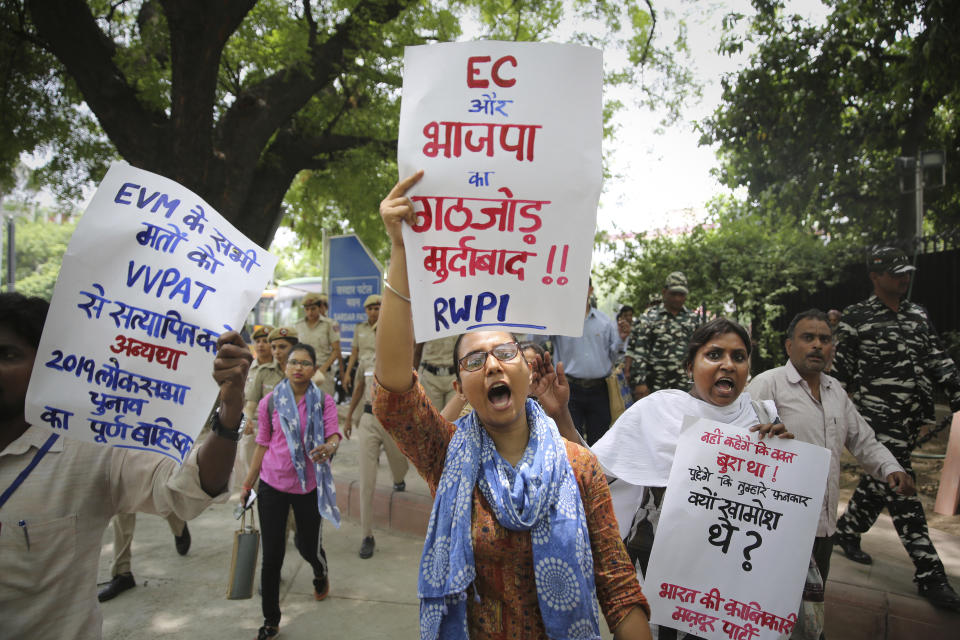 Activists of Revolutionary Workers' Party of India hold placards as they protest outside Election Commission office in New Delhi, India, Wednesday, May 22, 2019. India's Election Commission has rejected opposition fears of possible tampering of electronic voting machines ahead of Thursday's vote-counting to determine the outcome of the country's mammoth national elections. Placard in front reads, "Down with the collusion between Bhartiya Janata Party and Election Commission of India. (AP Photo/Altaf Qadri)