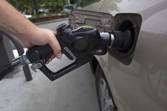 A person pumping gas into their car.