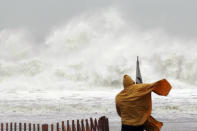 A Rehoboth Beach resident watches waves crash down in Delaware, Monday, Oct. 29, 2012. Hurricane Sandy continued on its path Monday, forcing the shutdown of mass transit, schools and financial markets, sending coastal residents fleeing for higher ground, and threatening a dangerous mix of high winds and soaking rain. (AP Photo/The Wilmington News-Journal, Suchat Pederson) NO SALES