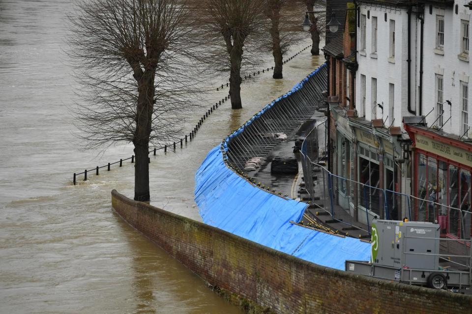Temporary flood barriers hold back the river Severn in Ironbridge (PA)