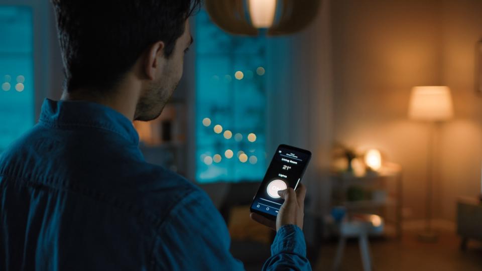 A man controlling his smart lights with his smartphone