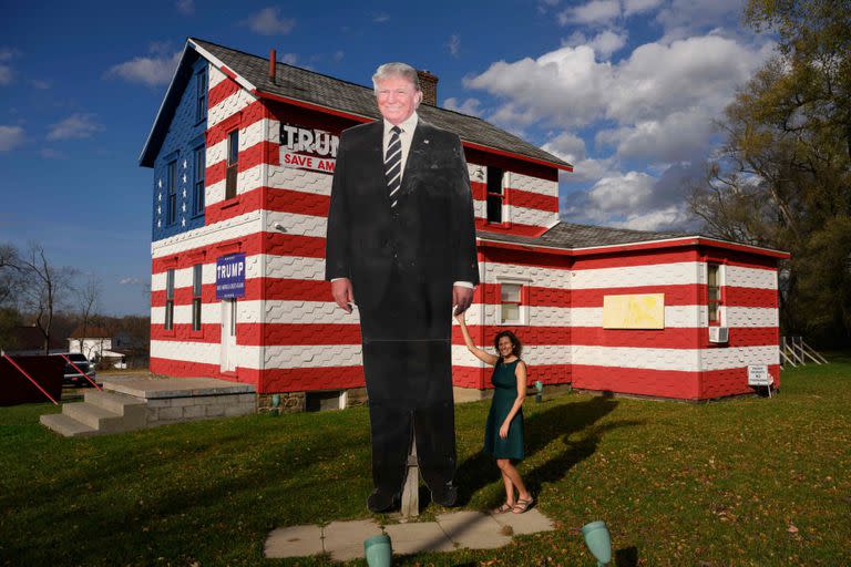 La representante del estado de Pensilvania, Leslie Rossi, posa con un recorte gigante del expresidente de los Estados Unidos, Donald Trump, frente a la "Casa Trump", de la que es propietaria y que creó en 2016, en Youngstown, Pensilvania, el 6 de noviembre de 2022. 