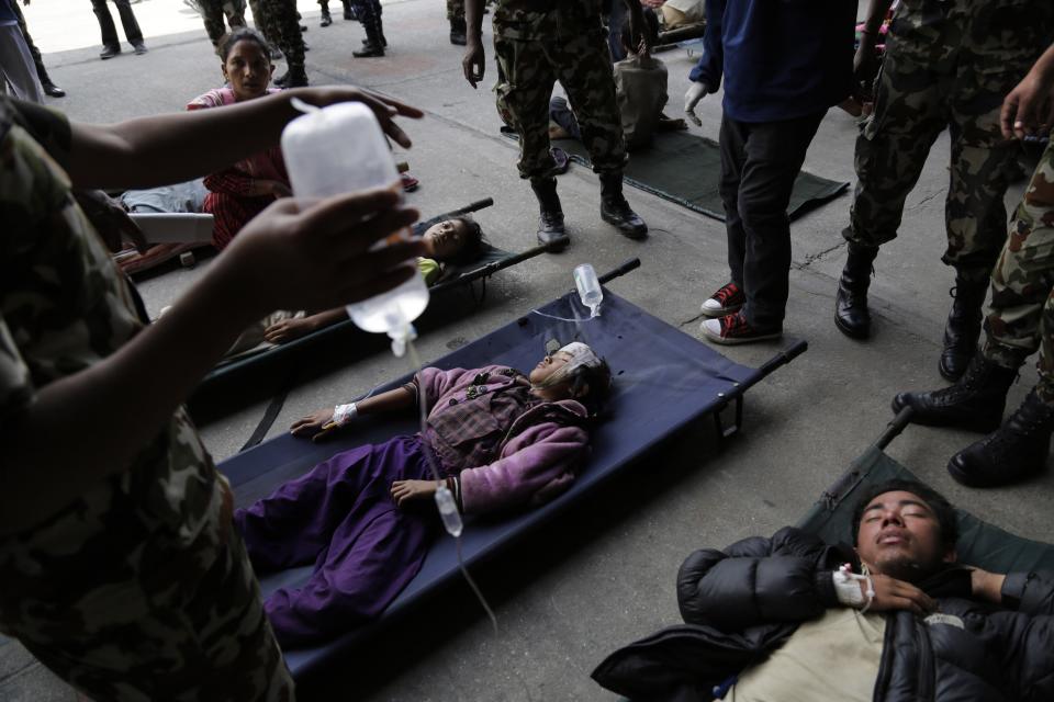 Victims of Saturday's earthquake lie on stretchers as they wait for ambulances after being evacuated at the airport in Kathmandu, Nepal, Monday, April 27, 2015. (AP Photo/Altaf Qadri)