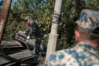 Sappers work next to a rocket case during the military conflict over the breakaway region of Nagorno-Karabakh, in Stepanakert