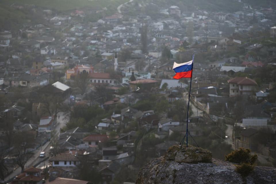 En esta foto de marzo de 2014, la bandera rusa ondea en la cima de una colina cerca de la ciudad de Bakhchysarai, Crimea. (AP Photo/Pavel Golovkin)