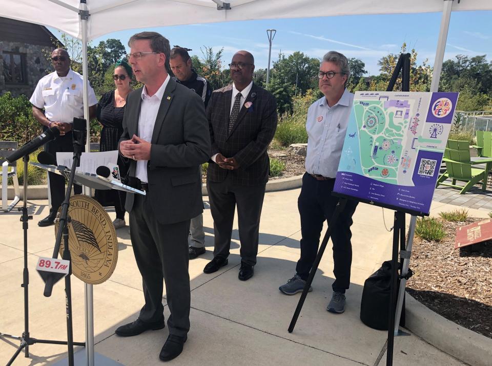 With a map of Fusion Fest at his side, South Bend Mayor James Mueller joins other city officials in speaking on Sept. 5, 2023, about the new event in Howard Park.