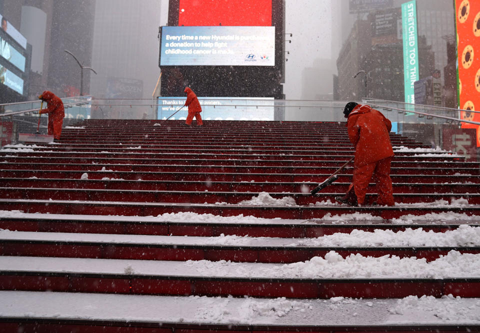 <p>Workers clean steps at Times Square in New York on March 21, 2018, as the fourth nor’easter in a month hits the tri-state area on the first full day of spring. (Photo: Timothy A. Clary/AFP/Getty Images) </p>