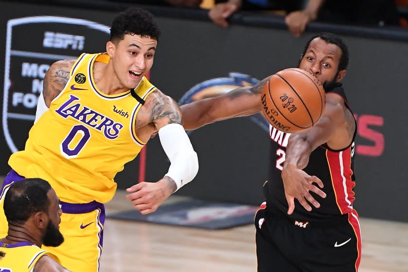 ORLANDO, FLORIDA OCTOBER 6, 2020-Lakers Kyle Kuzma and Heat's Andre Iguodala battle for a loose ball.