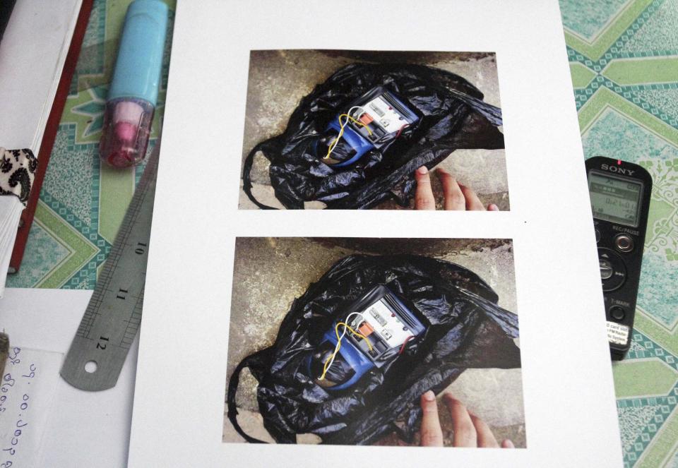 In this photo taken on Monday, Oct. 14, 2013, photographs of a homemade time bomb in a plastic bag found at a restaurant, is displayed at a police station in Yangon, Myanmar. Police urged vigilance after several small bombs exploded in and around Myanmar's largest city of Yangon in recent days. No one claimed responsibility for the blasts and it was not immediately clear if they were related. (AP Photo/Khin Maung Win)