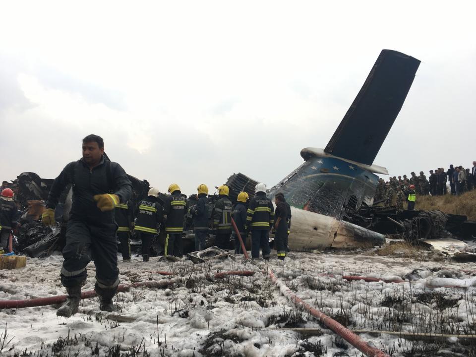 Rescuers surround the plane that crashed at Kathmandu Airport (Picture: AP)