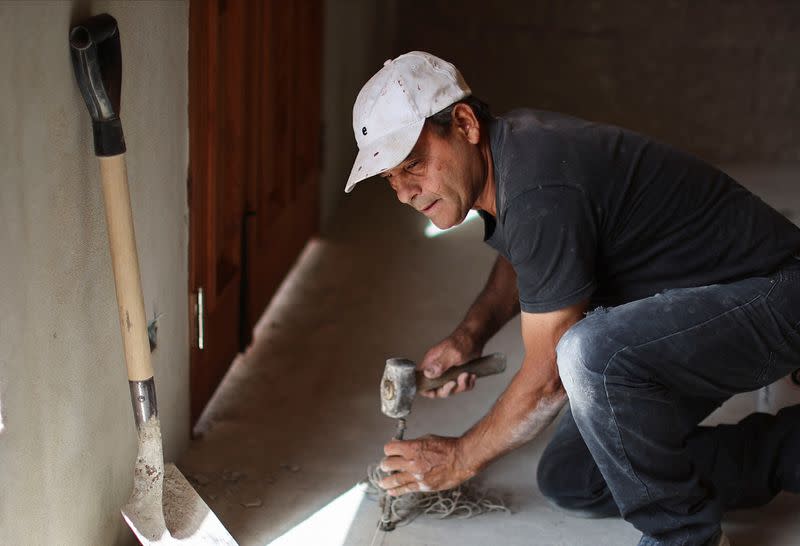 Bricklayer Jose Luis Rodriguez works in a house on the outskirts of Buenos Aires