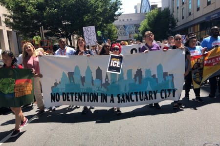 Activists protest President Donald Trump’s immigration policy as they march in Philadelphia