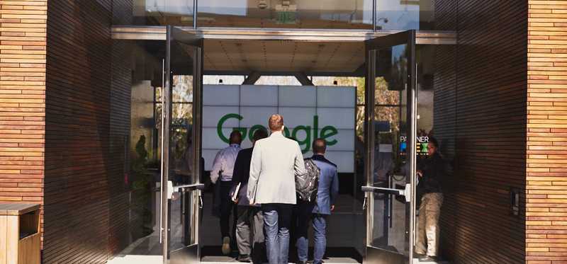 Executives walking into Google's headquarters entrance.