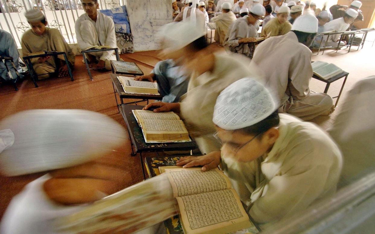 Pakistani religious students read the ho...Pakistani religious students read the holy Koran in a classroom of Jamia Binnoria, an Islamic school in Karachi - AFP