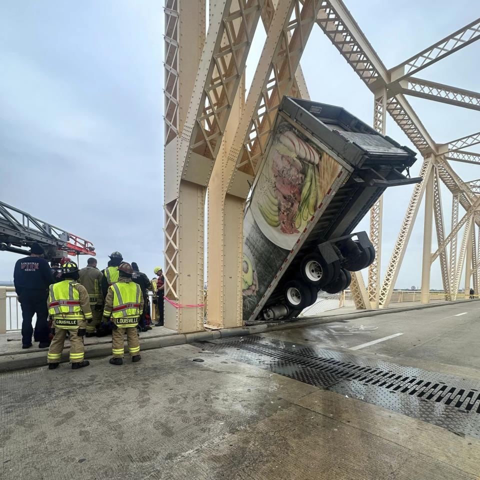 This photo provided by Louisville Division of Fire, Louisville Fire Dept. rescue the driver of semitruck that is dangling off the Clark Memorial Bridge over the Ohio River on Friday, March 1, 2024 in Louisville, Ky. The driver was pulled to safety by firefighters following the three-vehicle crash on the bridge connecting Louisville, Kentucky to southern Indiana(Louisville Division of Fire via AP)