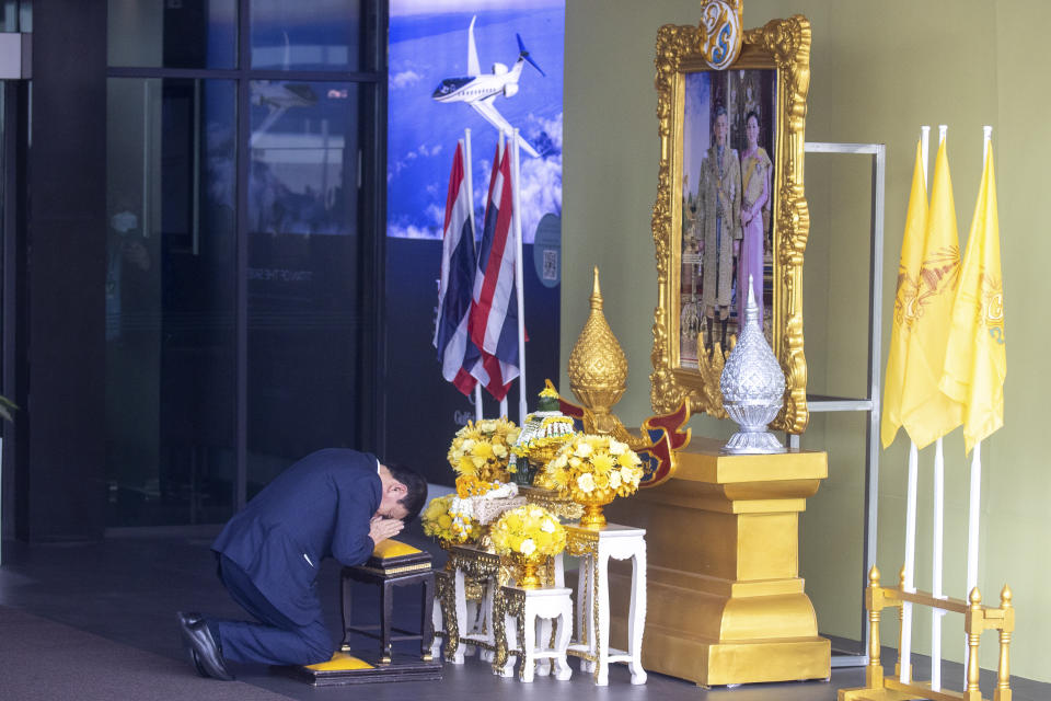 Thailand's former Prime Minister Thaksin Shinawatra prays in front of a portrait of King Maha Vajiralongkorn as he arrives at Don Muang airport in Bangkok, Thailand, Tuesday, Aug. 22, 2023. (AP Photo/Wason Wanichakorn)