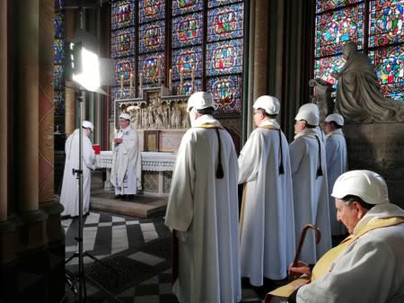 The Archbishop of Paris Michel Aupetit leads the first mass in a side chapel two months to the day after a devastating fire engulfed the Notre-Dame de Paris cathedral, in Paris