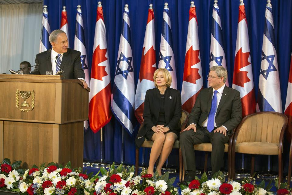 Israel's PM Netanyahu delivers a speech as his Canadian counterpart Harper and his wife Laureen listen during a welcoming ceremony for Harper in Jerusalem