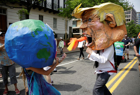 Protesters dressed as the earth and U.S. President Donald Trump pretend to fight during the Peoples Climate March near the White House in Washington, U.S., April 29, 2017. REUTERS/Joshua Roberts