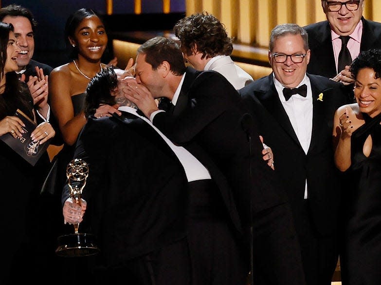 Matty Matheson and Ebon Moss-Bachrach kiss with the cast of 'The Bear' at the 75th Primetime Emmy Awards at the Peacock Theater in Los Angeles, CA, Monday, Jan. 15, 2024.