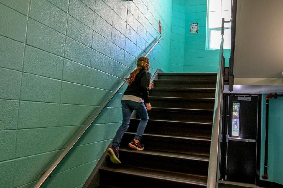 A student catches up to her classmates in the stairway at Hathaway Elementary School in Portsmouth.