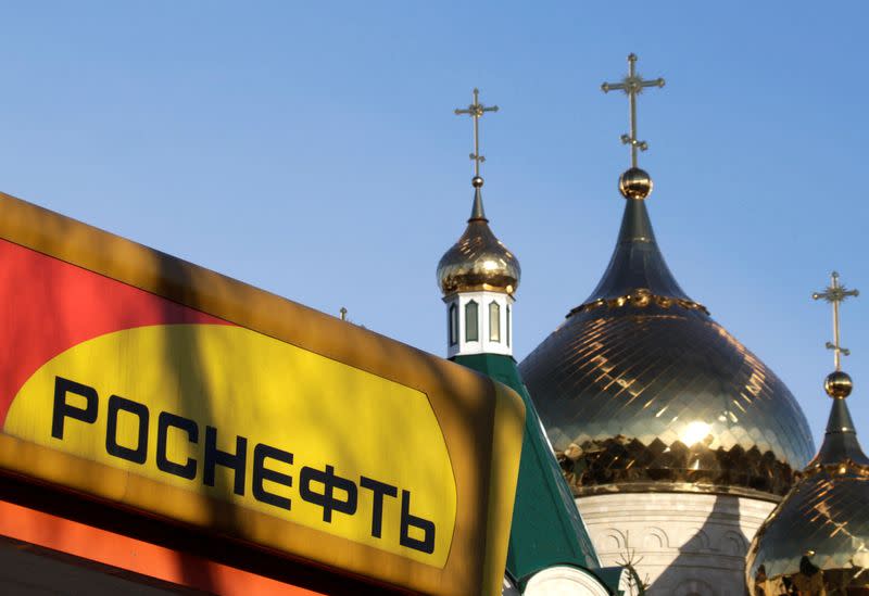 FILE PHOTO: The logo of Russia's top crude producer Rosneft is seen on a gasoline station near a church in Stavropol