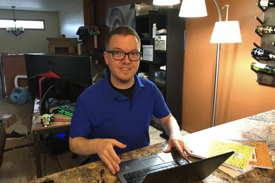 Brenton Nesemeier, who manages COVID-19 case managers and field managers at the North Dakota Department of Health, works at his home in Fargo, N.D., on Dec. 11, 2020. He said the state curtailed much of its contact tracing among the general public as the virus surged, and relying on people who test positive to tell anyone they were in close contact with. (Zachery Noble via AP)