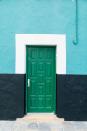 <p>Cool colors come together around a bright green door.</p>