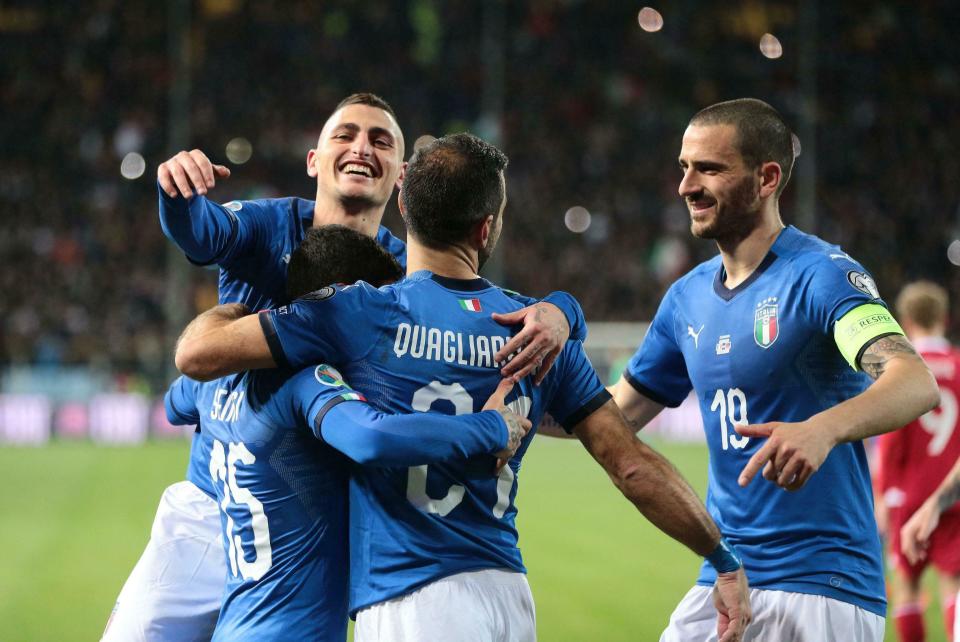 Italy's Fabio Quagliarella, back to camera, jubilates with his teammates Leonardo Bonucci, right, Stefano Sensi, covered, and Marco Verratti, left, after scoring his team's fourth goal during a Euro 2020 Group J qualifying soccer match between Italy and Liechtenstein, at the Ennio Tardini stadium in Parma, Italy, Tuesday, March 26, 2019. (Serena Campanini/ANSA via AP)