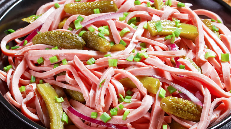 fleischwurst with chopped gherkins on a dark plate