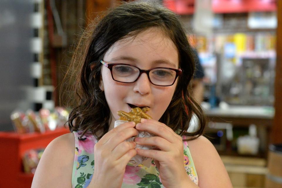 Abigile Biddle, 9, visiting River Street Sweets with her parents from Charleston eats a praline.  On Wednesday's National Praline Day, River Street Sweets, Savannah's Candy Kitchen along with parent companies River Street Sweets and Savannah Candy Kitchen will donate 10 percent of all praline sales to the America's Second Harvest's Kids Cafe.