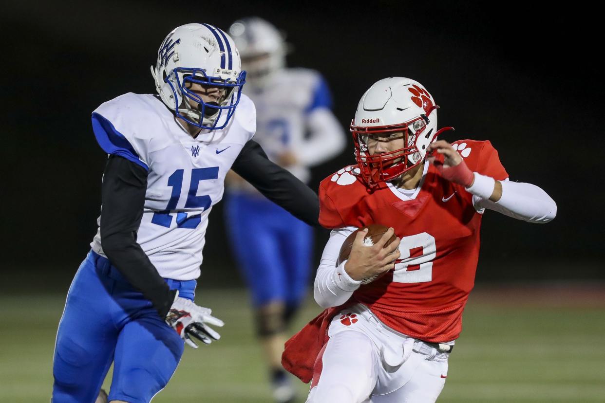 Beechwood quarterback Cameron Hergott (2) runs with the ball against Walton-Verona linebacker Logan Ryan (15) in the first half at Beechwood High School. Nov. 19, 2021