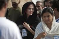 Actress Angelina Jolie (C) arrives at the Jalozai flood victim relief camp during her visit to flood affected areas and relief camps supported by the UNHCR (United Nations High Commissioner for Refugees), in Pakistan's northwest Khyber-Pakhtunkhwa Province, September 7, 2010. Jolie called for constant and long-term assistance for Pakistan to help it cope with its worst ever floods that have wreaked havoc on the impoverished country.